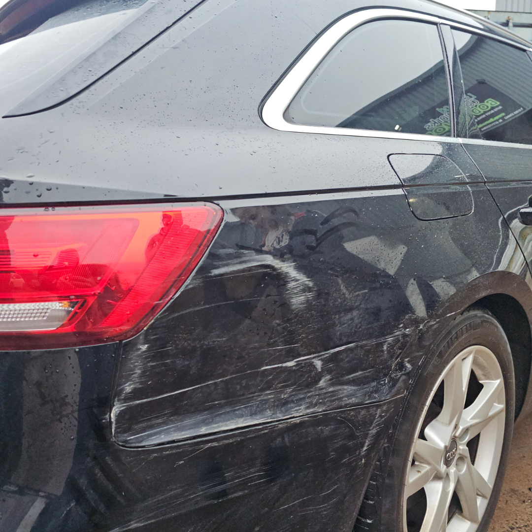 Black Audi estate with scratch and scuff damage to rear quarter panel